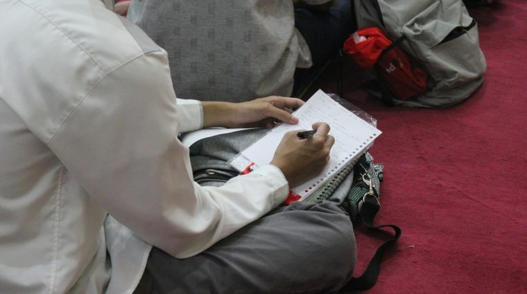 a person writing on a piece of paper