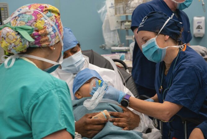 Medical team attends to newborn baby in hospital.