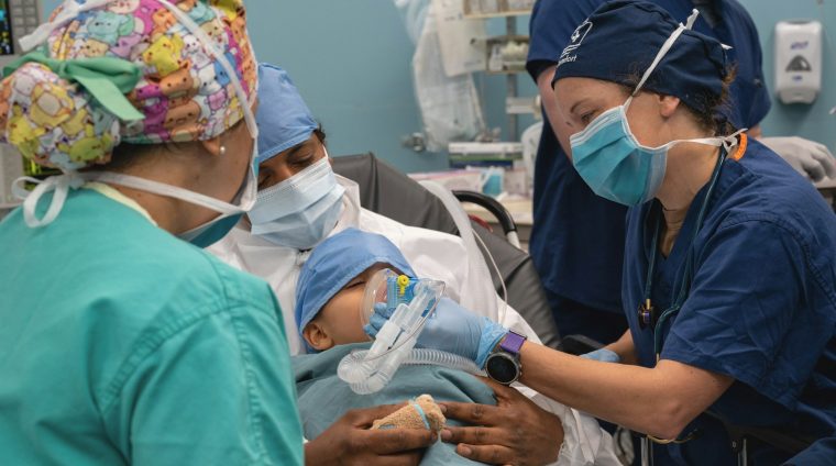 Medical team attends to newborn baby in hospital.